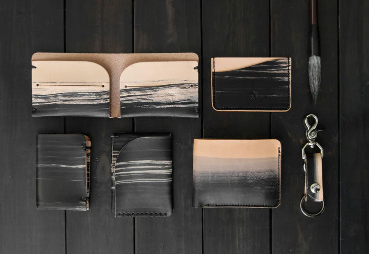 A collection of leather items hand painted in black brush strokes with a sumie brush along side