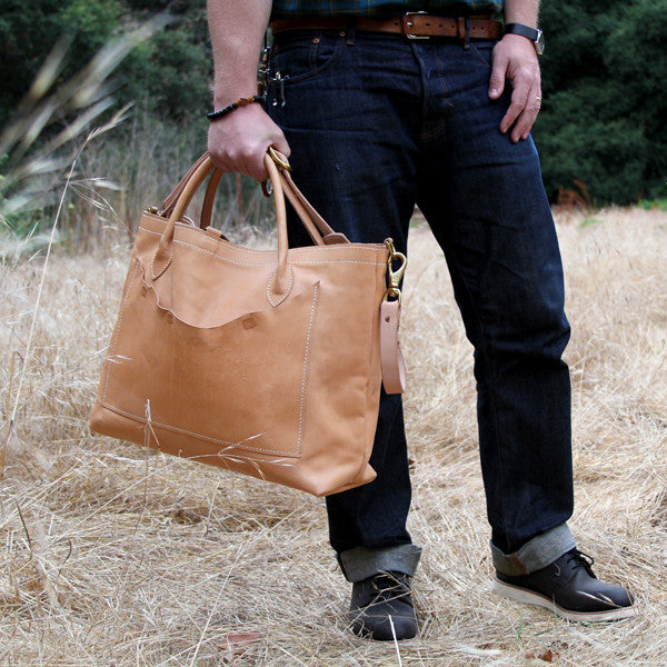 Man carrying large leather veg tan travel bag
