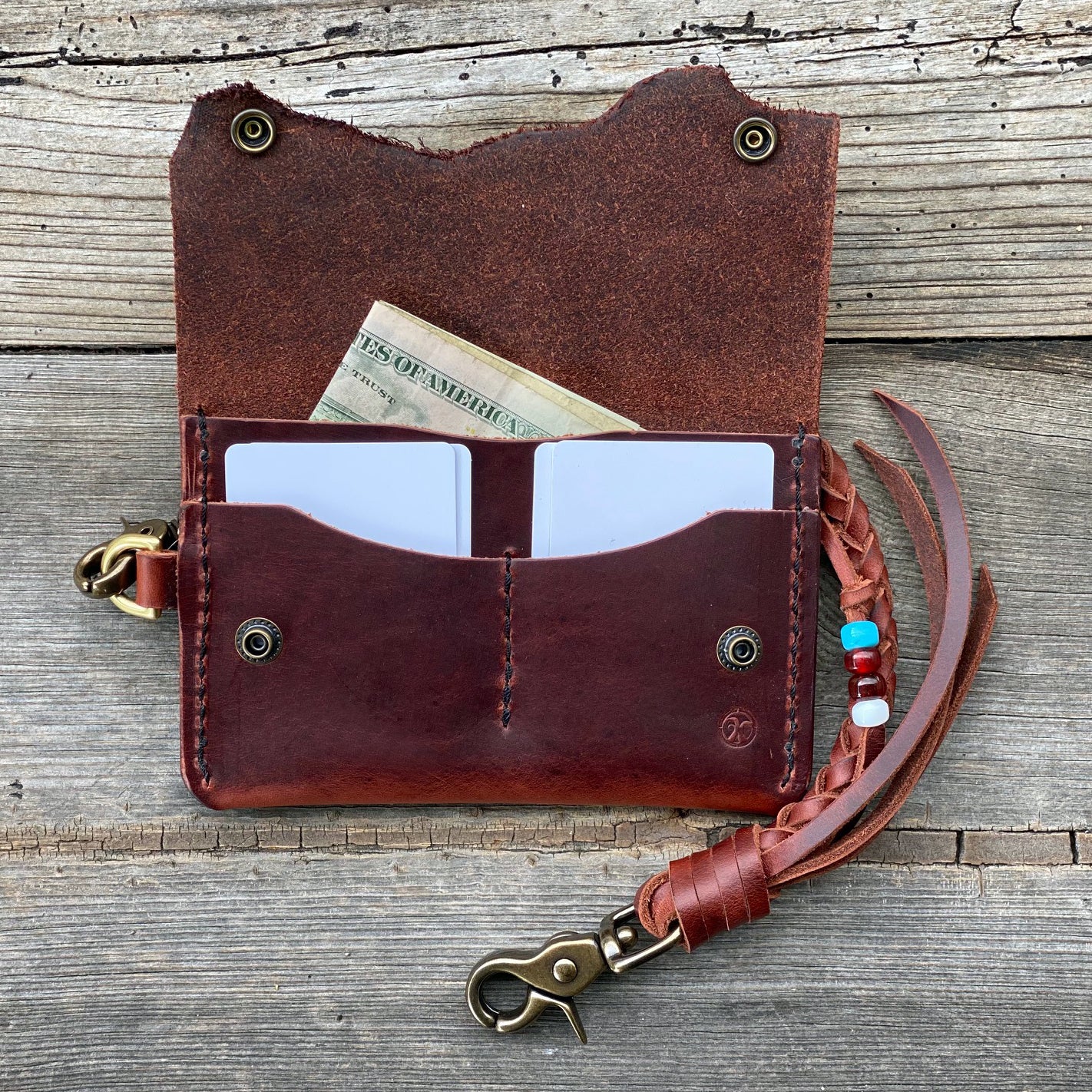 Hand crafted mid sized leather trucker wallet open showing money and cards